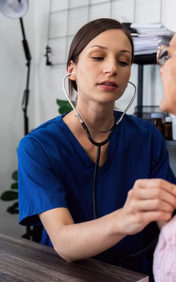 Doctor listens to heartbeat of older of retirement age to check their heart rate